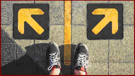 Two feet standing on tarmac betfore two arros indicating a choice of direction